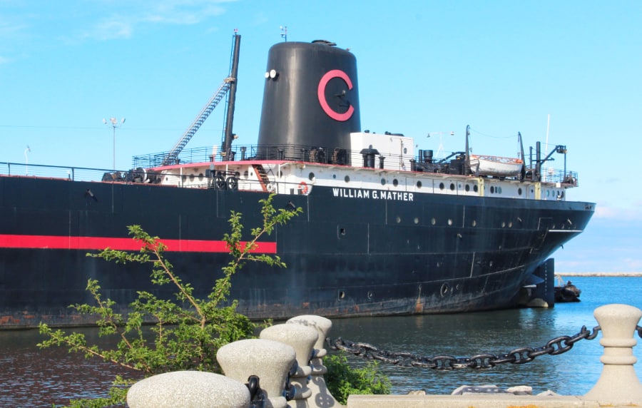 Large black steamship docked in the water with the name William G Mather